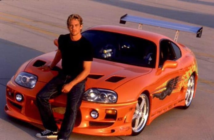 Paul Walker e o icônico Toyota Supra laranja de 'Velozes e Furiosos'. Imagem: Universal Pictures/Reprodução