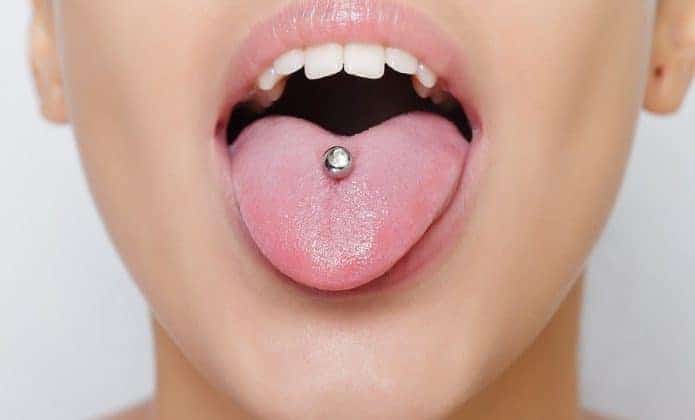 beautiful-woman-sticking-out-her-tongue-and-showing-young-piercing-picture-id492811982-695x420