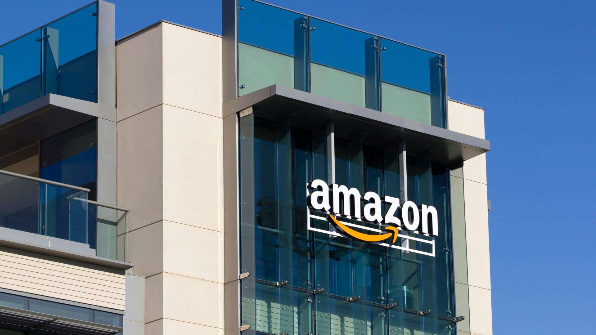 Imagem mostra a fachada de um prédio da Amazon, com o logotipo da empresa no topo.