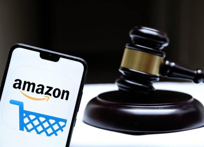 Logo da Amazon exibido em celular ao lado de um martelo de tribunal