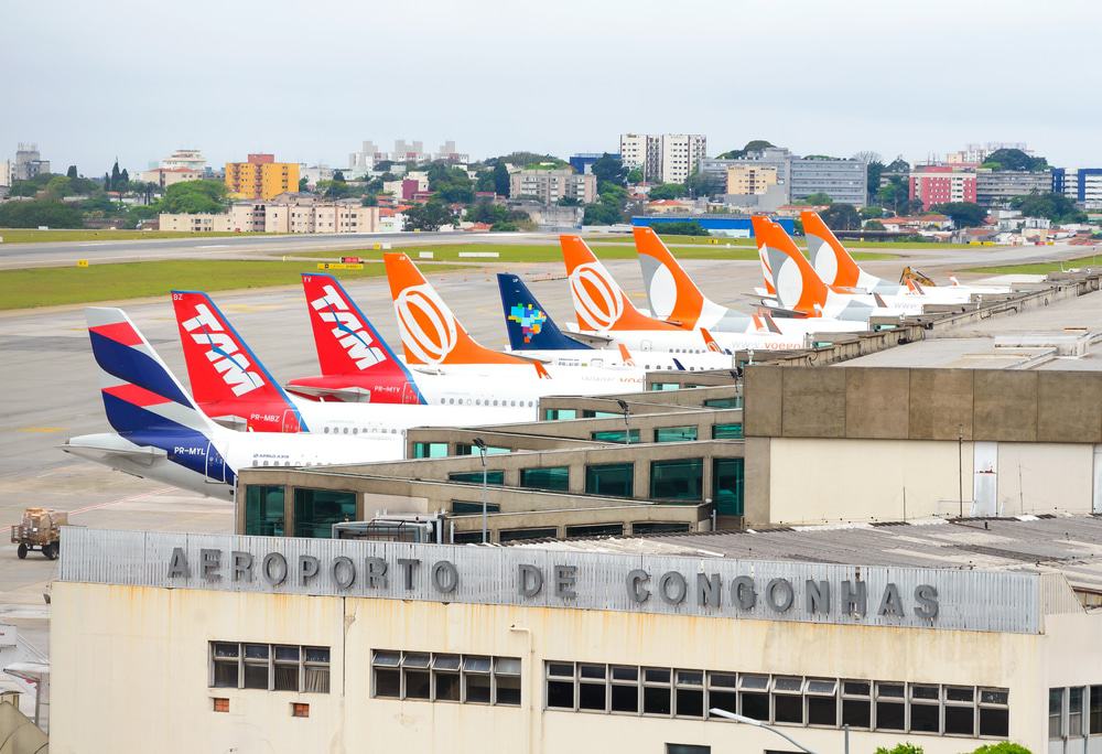 Fachada do Aeroporto de Congonhas, em São Paulo, com caudas de aviões ao fundo 