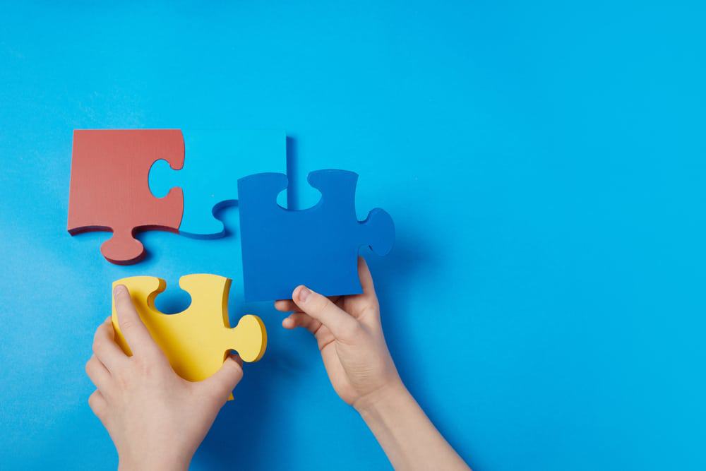 Criança com dificuldade de terminar um quebra-cabeça. Homens com autismo prestam mais atenção a detalhes. 