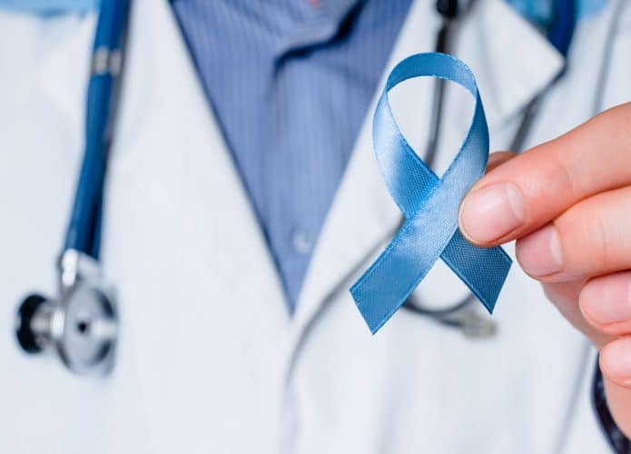 Médico segurando uma fita azul em representação a consciência do câncer de próstata