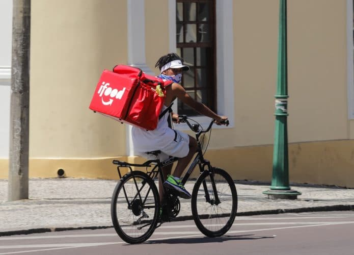 Homem de bicicleta com uma mochila térmica do iFood