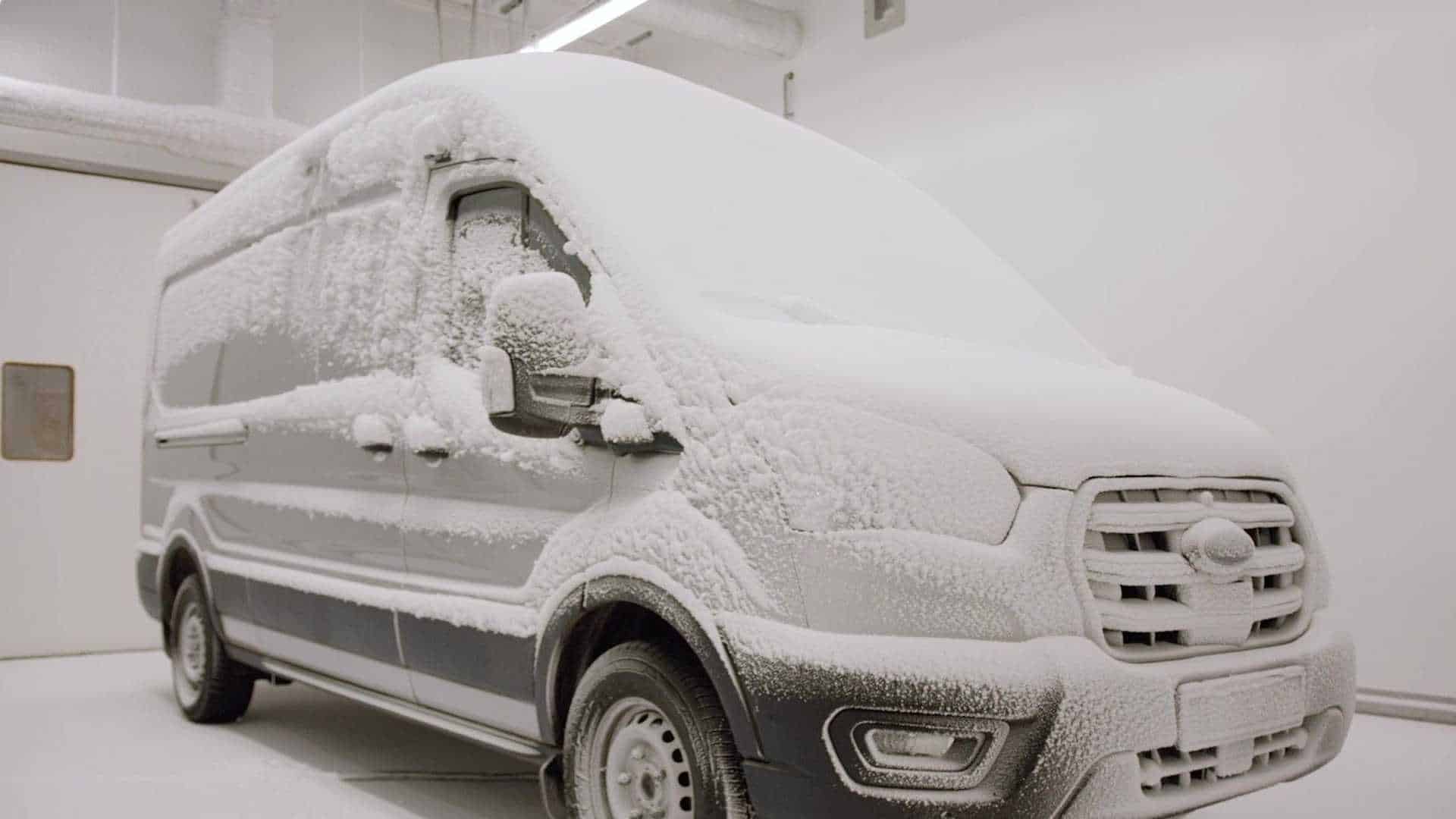 Imagem exibe Ford E-Transit coberto de neve em sala de testes.