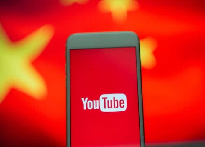 Logo do YouTube exibido em smartphone e ao fundo uma bandeira da China