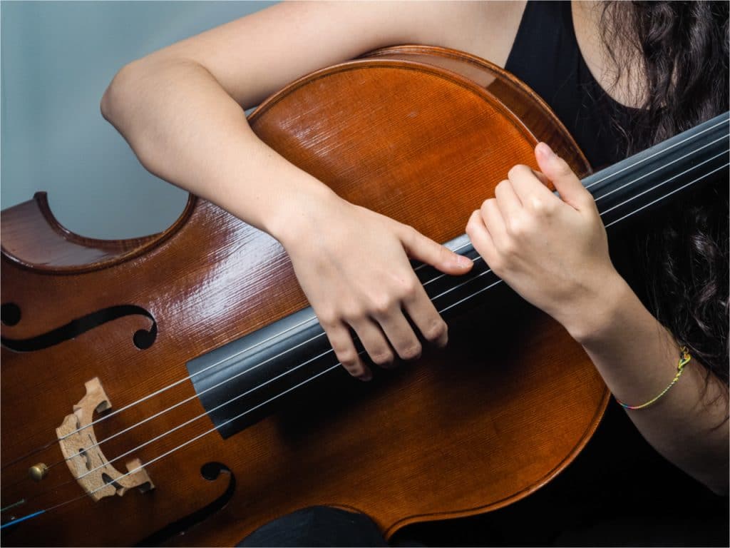 Imagem mostra uma mulher segurando um violoncelo, um instrumento bastante usado na noruega, onde cientistas estão usando a inteligência artificial para expandir o gosto musical das pessoas