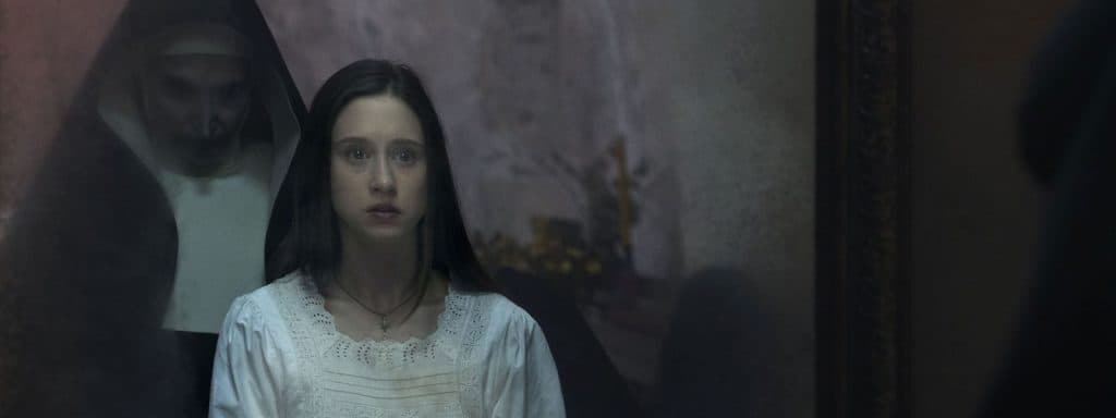 Em cena do filme, a noviça Irene (Taissa Farmiga) vê a freira Valak em reflexo no espelho.