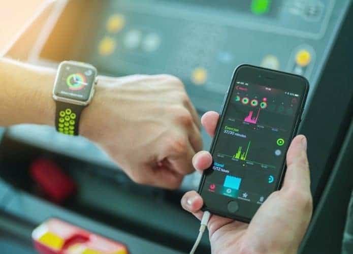 Homem com Apple Watch e iPhone aberto