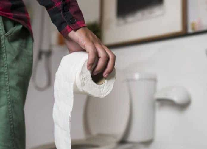 Homem segurando papel higiênico