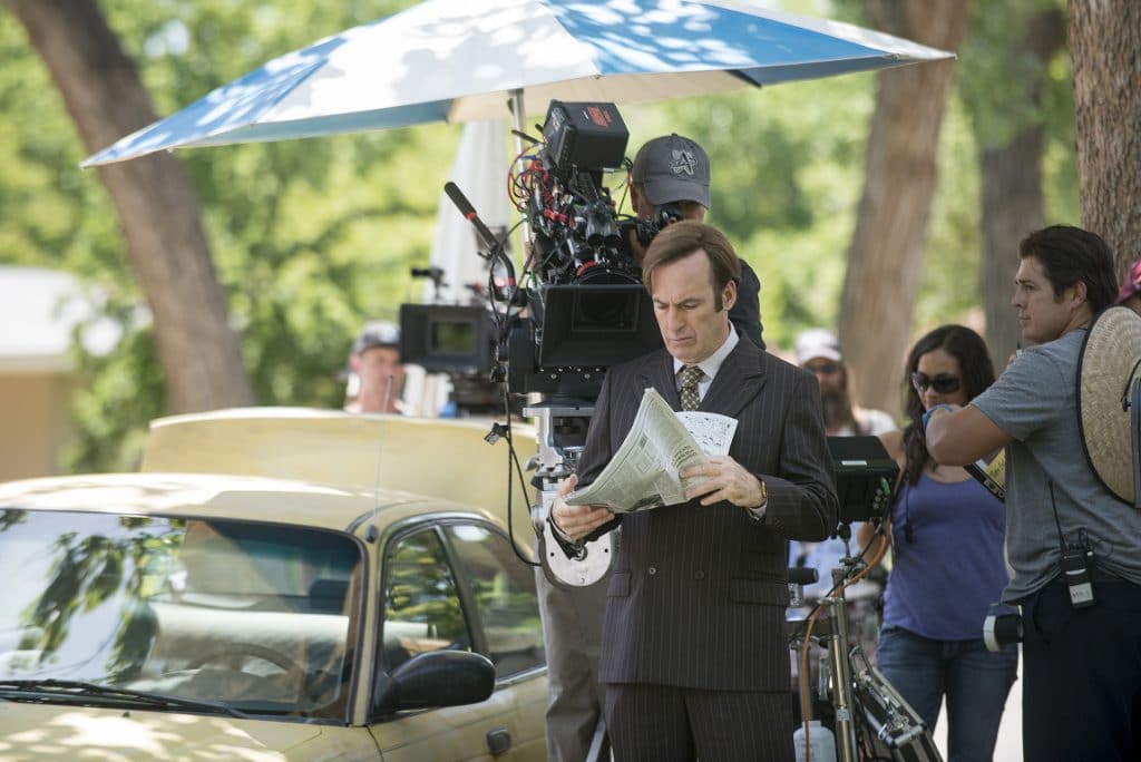 Ator Bob Odenkirk aparece trajando terno e segurando jornal em foto que registra filmagens de Better Call Saul