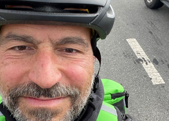 Na imagem, Dara Khosrowshahi, CEO da Uber, realizando entregas pelo Uber Eats nas ruas de São Francisco, nos Estados Unidos; ele aparece com capacete, de bicicleta e mochila de entrega