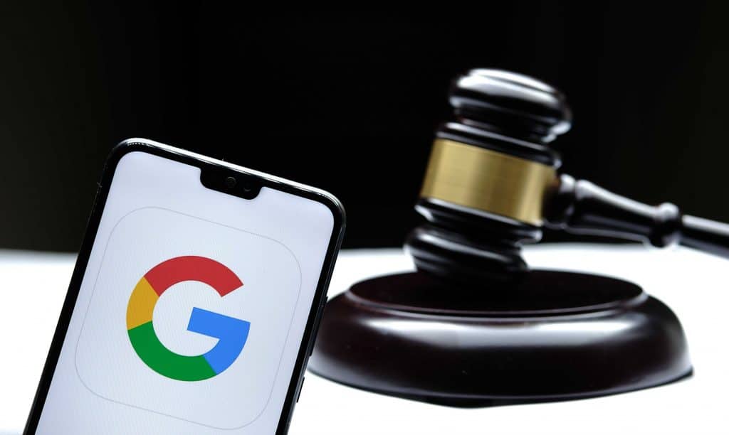 Logo do Google exibido em smartphone ao lado de um martelo de tribunal