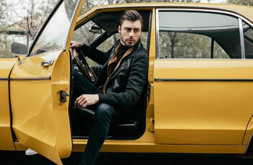 Homem saindo de um carro antigo
