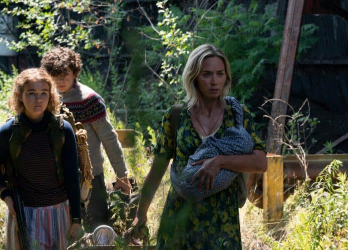 Emily Blunt, Millicent Simmonds e Noah Jupe caminham pela mata cena do filme.