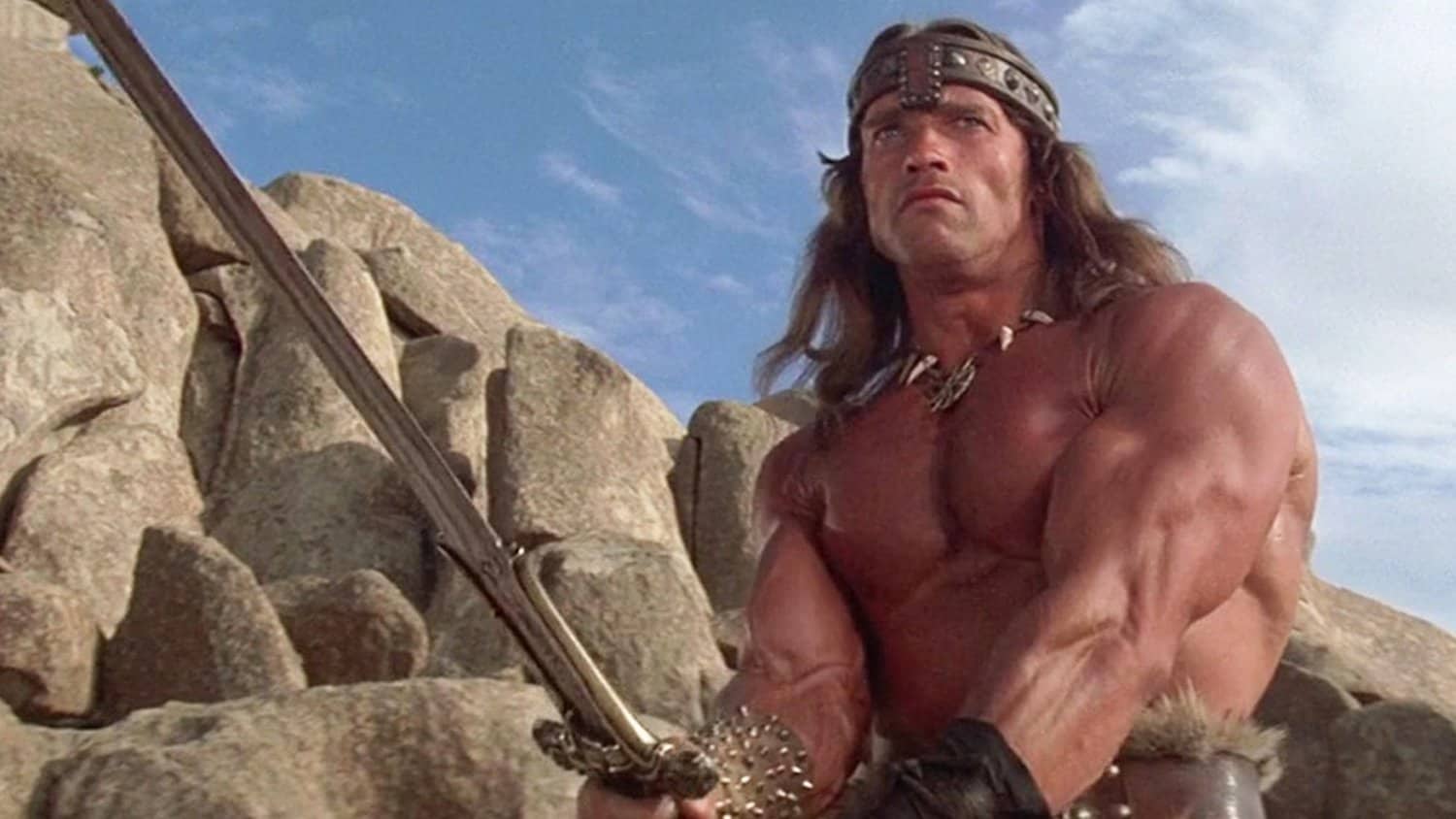 Arnold Schwarzenegger aparece em foto caracterizado como Conan, empunhando uma espada e com o torso nu