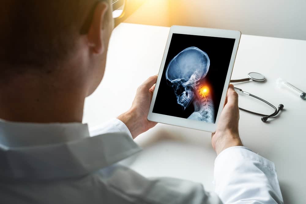 médico vendo diagnostico de câncer no pescoço