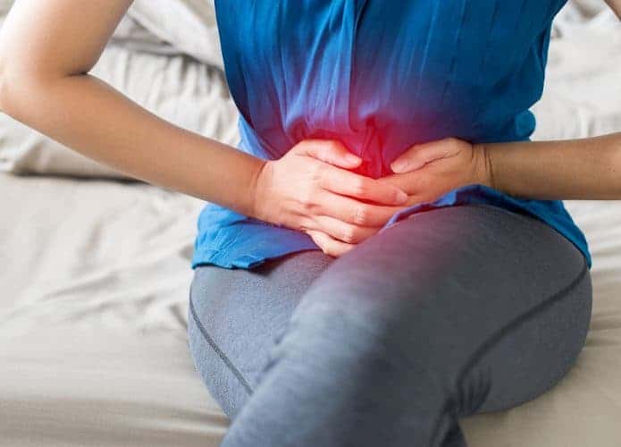 Mulher com cólica menstrual apertando a barriga