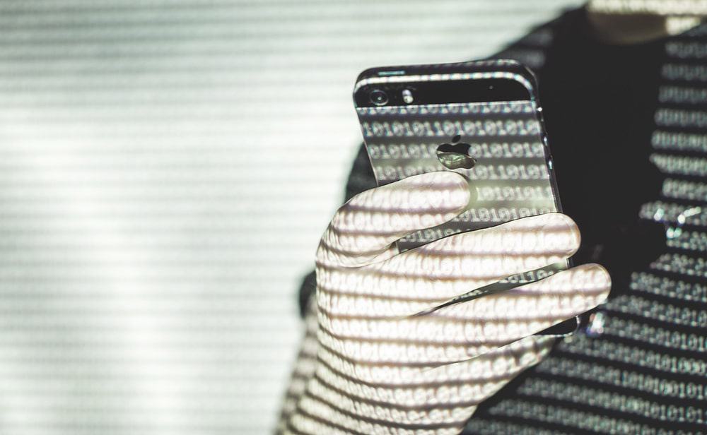 Imagem mostra um homem segurando um iPhone