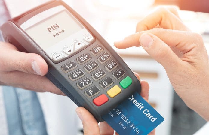 Consumidor pagando uma compra com cartão de crédito em uma