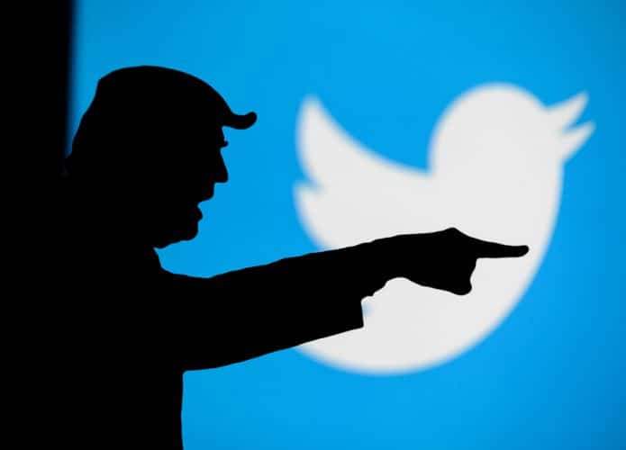 Imagem mostra a silhueta do ex-presidente dos EUA, Donald Trump, de perfil; ao fundo há o logo do Twitter