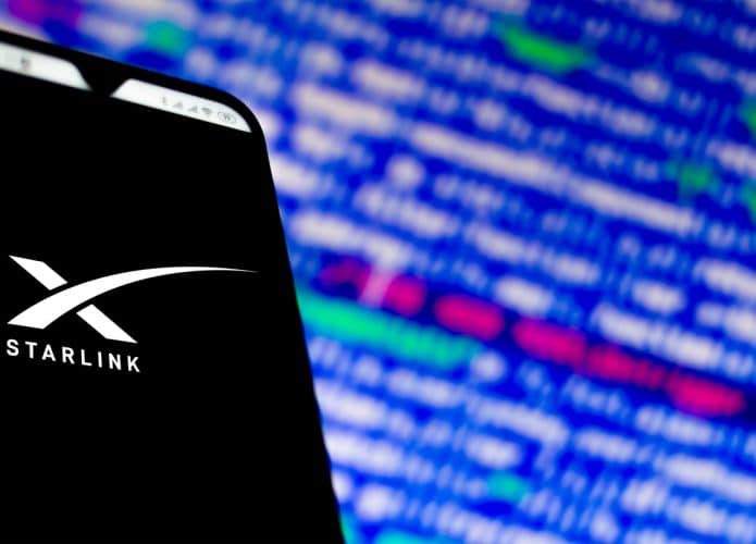 Imagem mostra a tela de um celular com a logomarca da Starlink em sua tela