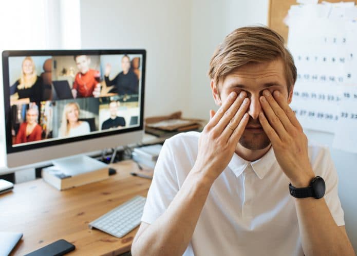 Homem de costas para o computador durante uma videoconferência