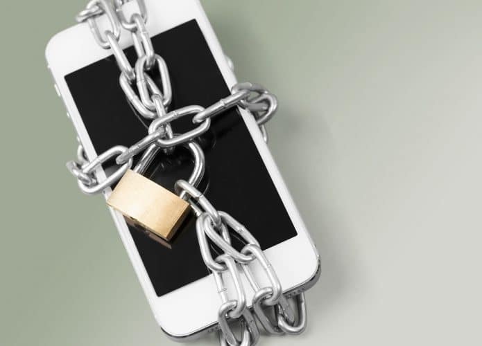 Imagem mostra um iPhone envolto com uma corrente fechada com um cadeado