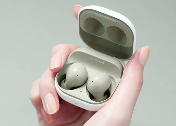 Imagem mostra uma mão de mulher segurando um case aberto onde, dentro, podemos ver os fones Galaxy Buds 2