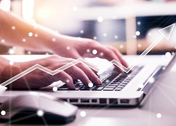 Imagem mostra um par de mãos digitando algo no teclado de um notebook