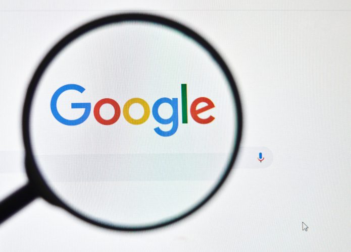 Logotipo da página de pesquisa do Google através de uma lupa na tela de um computador