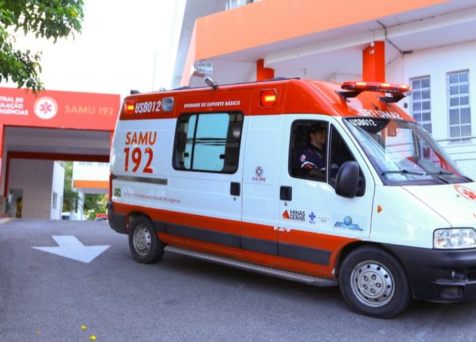 Imagem mostra uma ambulância do SAMU estacionada em frente a um hospital, em Divinópolis, Minas Gerais