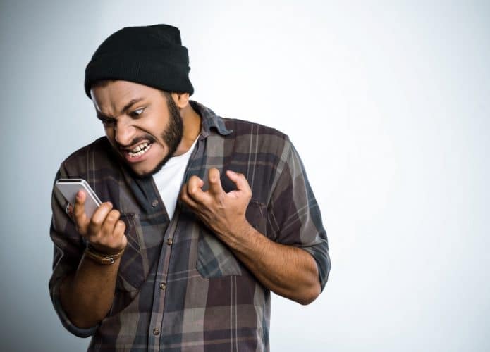 Homem jovem gritando com o celular