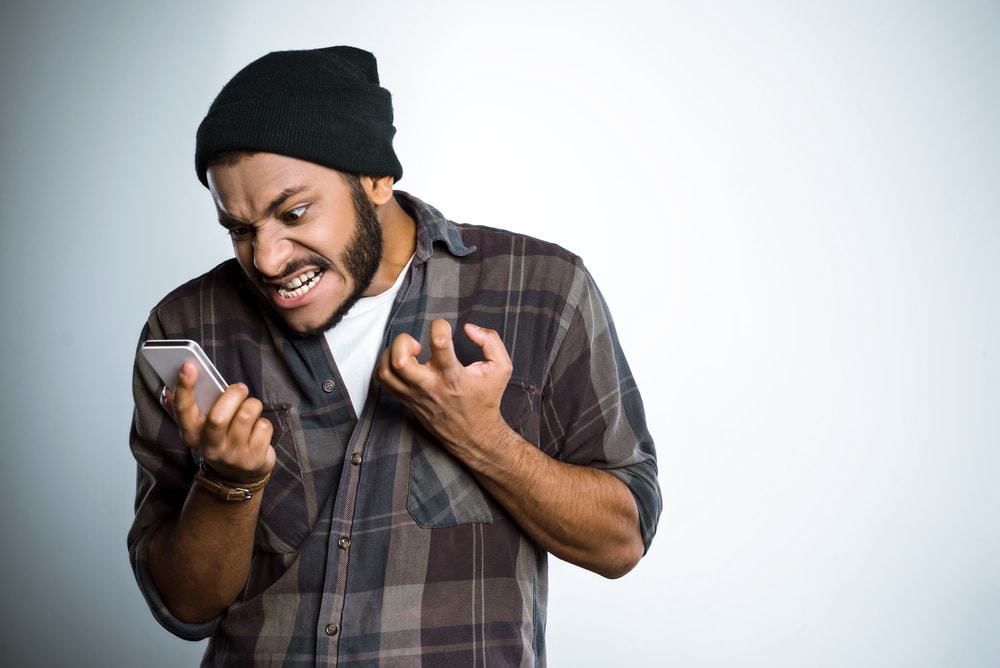 Homem jovem gritando com o celular