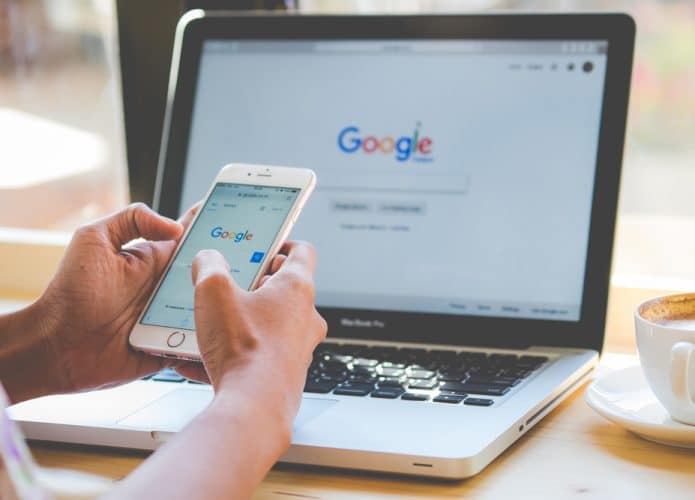Mulher digitando no mecanismo de pesquisa do Google em um laptop