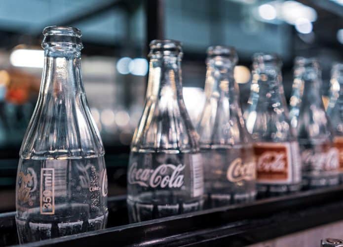 Imagem mostra garrafas de vidro com o logotipo da Coca-Cola enfileiradas