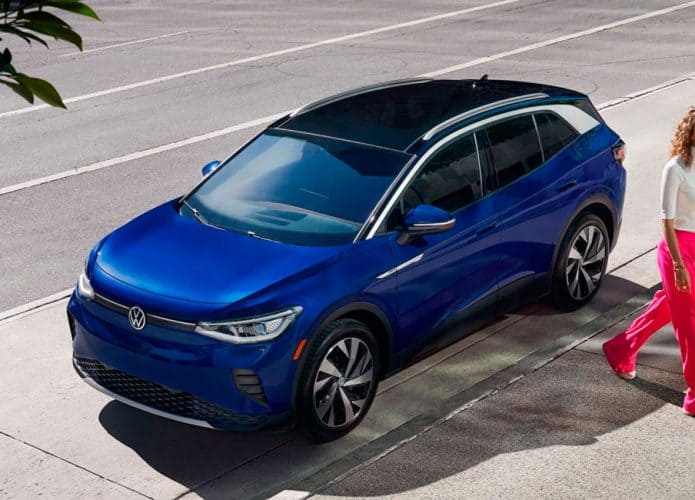 carro da volkswagen estacionado enquanto mulher caminha na calçada