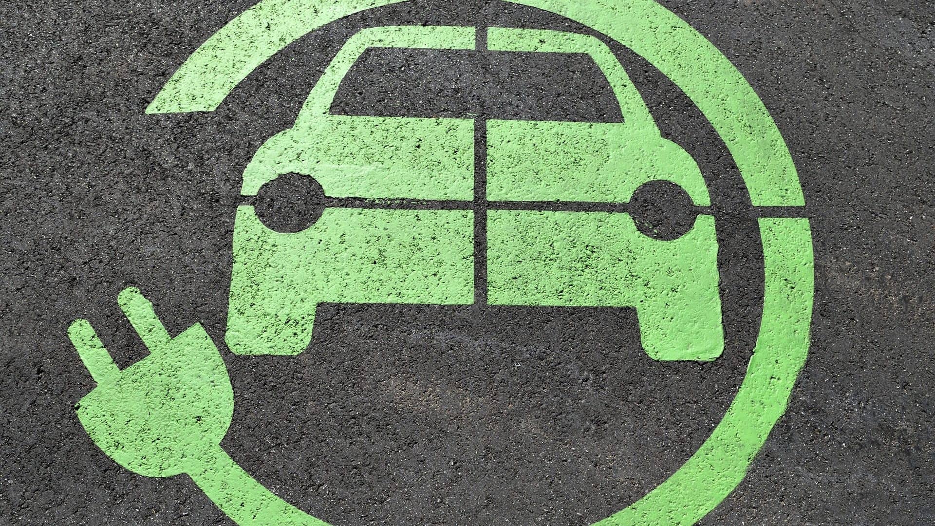 Desenho de um carro elétrico envolvido por um fio de tomada simbolizando local para carregamento, que poderá se tornar mais desnecessário em estradas dotadas de carregamento sem fio