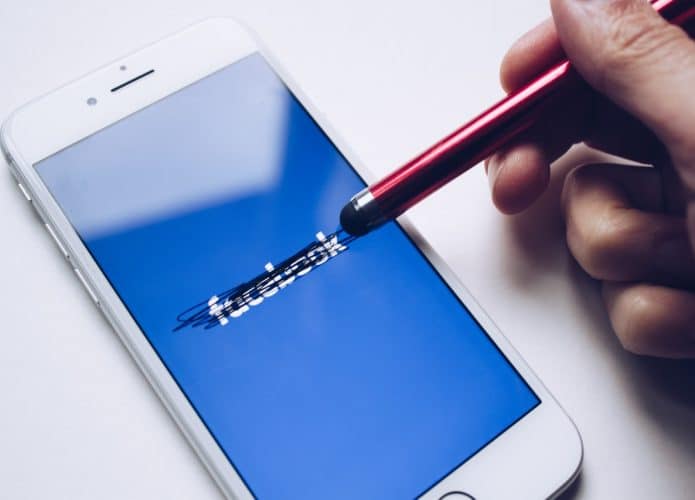 Facebook e fake news: tela de celular com logo riscado
