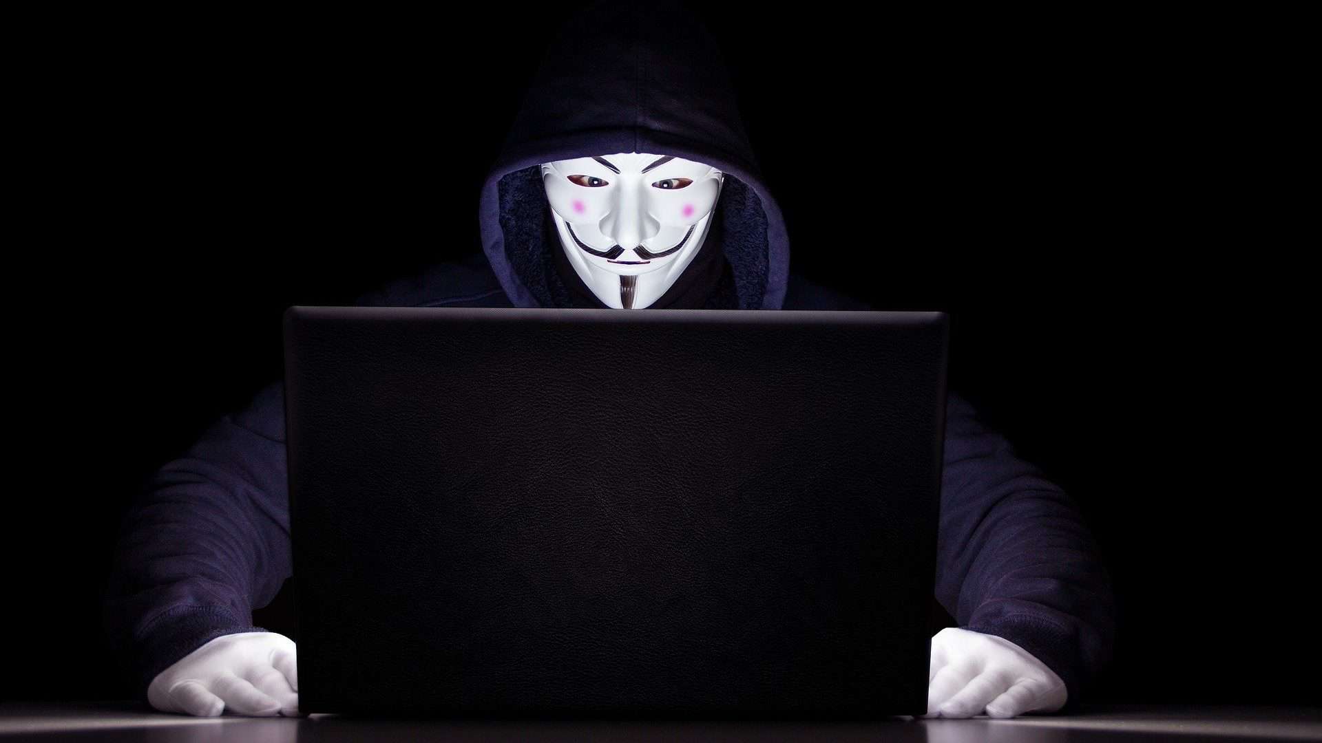 hacker do anonymous com máscara do guy fawkes na frente do notebook