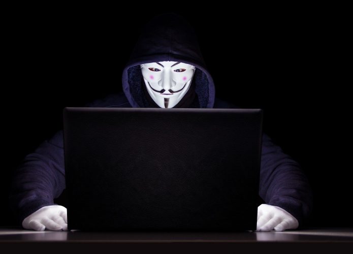 hacker do anonymous com máscara do guy fawkes na frente do notebook