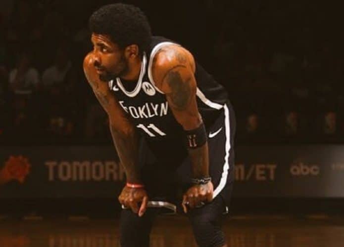 Kyrie Irving com as mãos nos joelhos