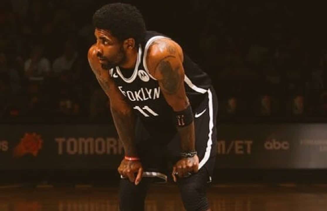 Kyrie Irving com as mãos nos joelhos