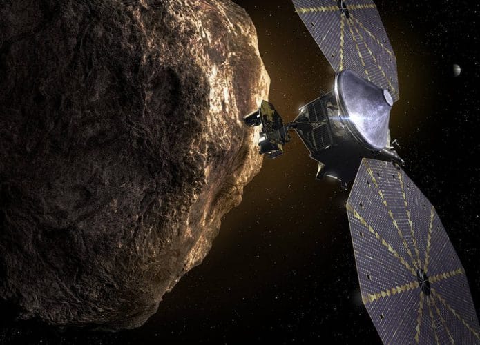 Ilustração mostra espaçonave Lucy com seus dois paineis solares ao lado de um asteroide