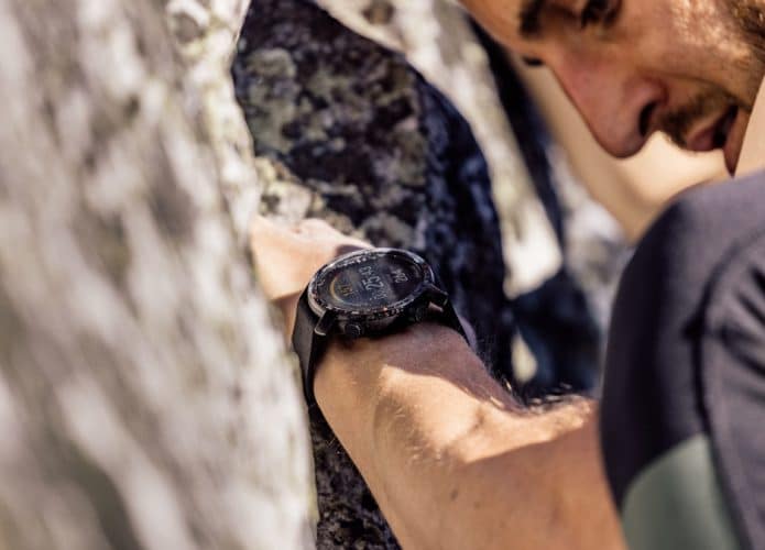 Polar Grit X Pro no braço de um homem escalando uma montanha