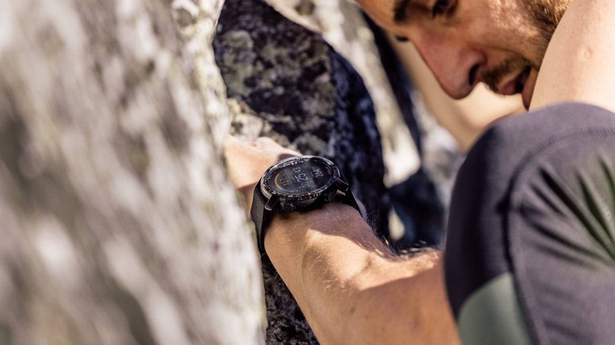 Polar Grit X Pro no braço de um homem escalando uma montanha