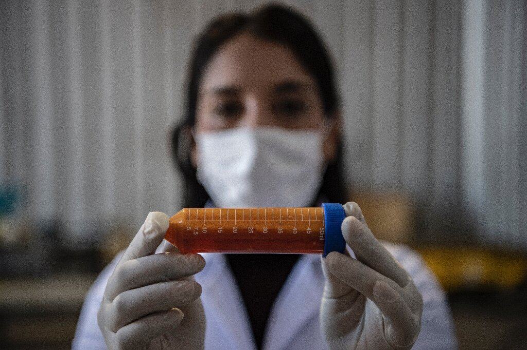 A biotecnóloga Nadac Reales, segurando um tubo contendo a bactéria que se alimenta de metal