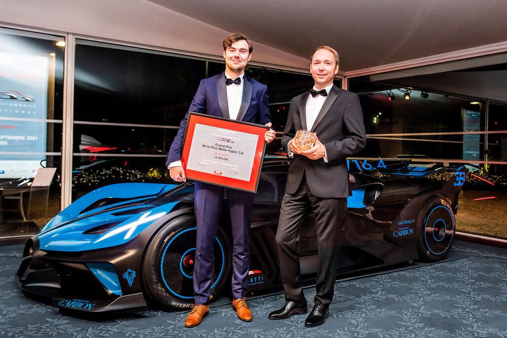 representante do premio segurando certificado na frente do bugatti bolide