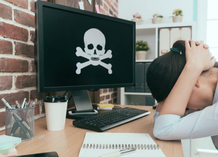 mulher frustrada enquanto computador está com caveira e ossos