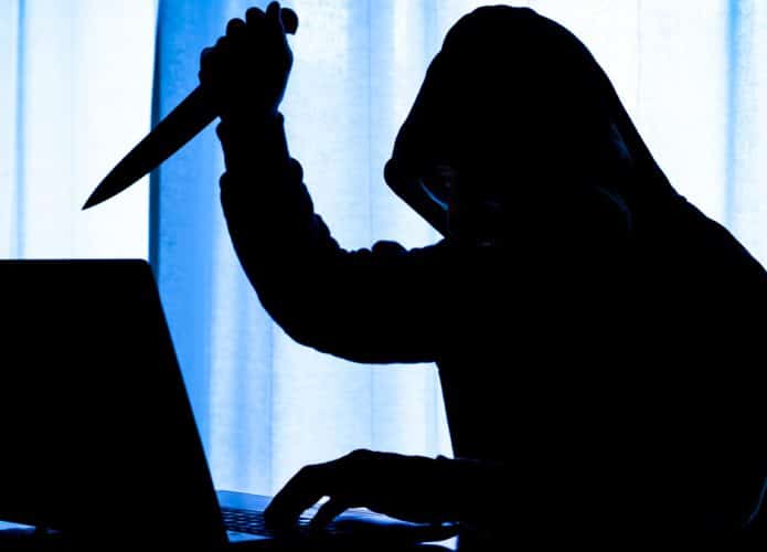 hacker assassino brandindo faca na frente do computador